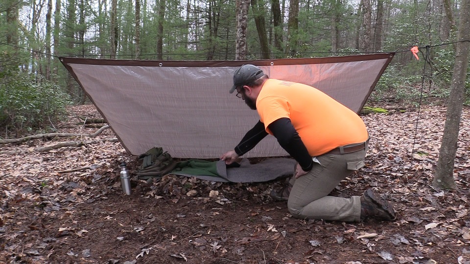 Art Dawes prepares a shelter in the woods.
