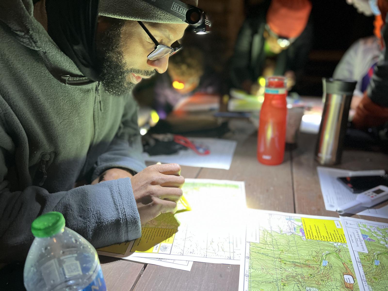 Looking at trail maps at night photo by Rootstock Racing PA Wilds